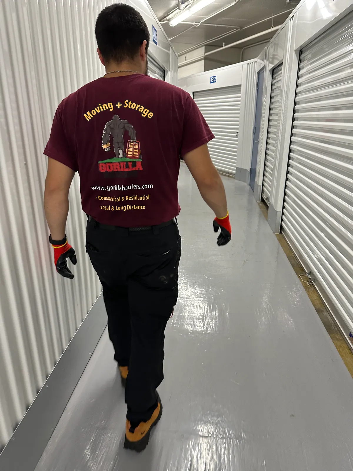 Gorilla Haulers mover walking down the hallway of an indoor, climate-controlled storage facility