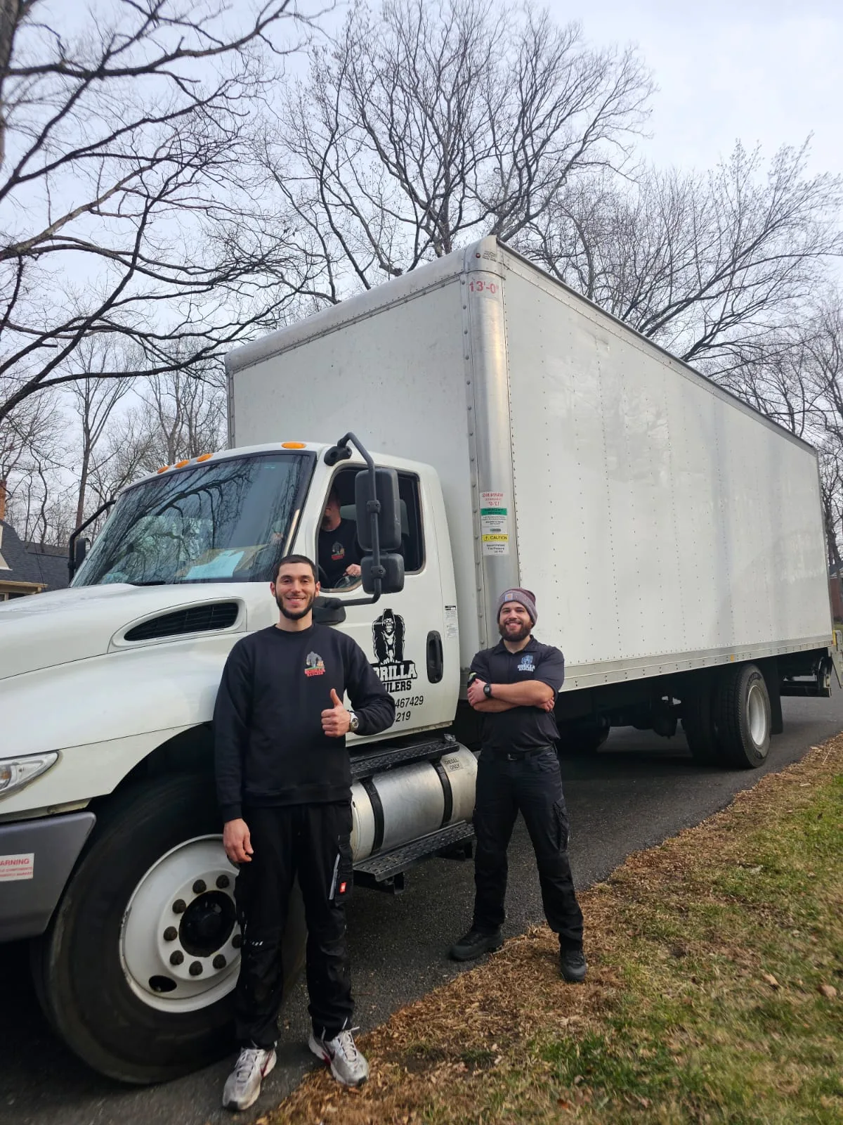 Gorilla Haulers team members in company shirts beside their moving truck