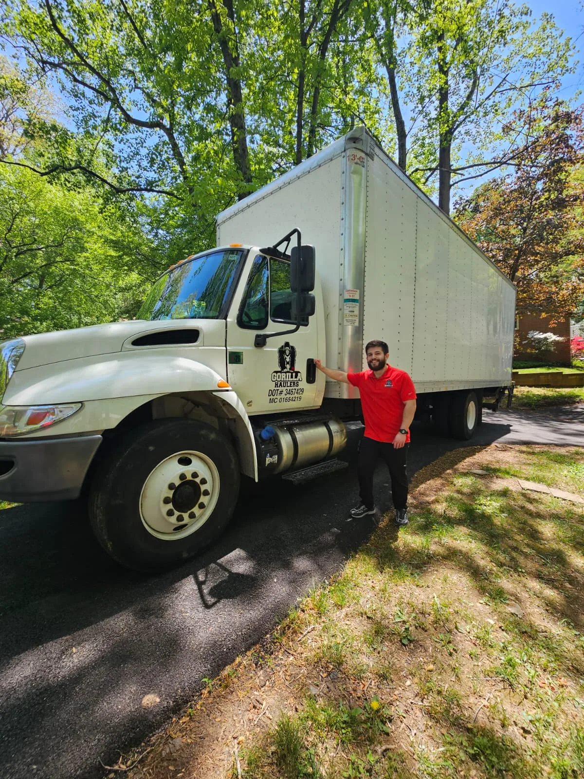 Gorilla Haulers team member standing beside a company-branded box truck