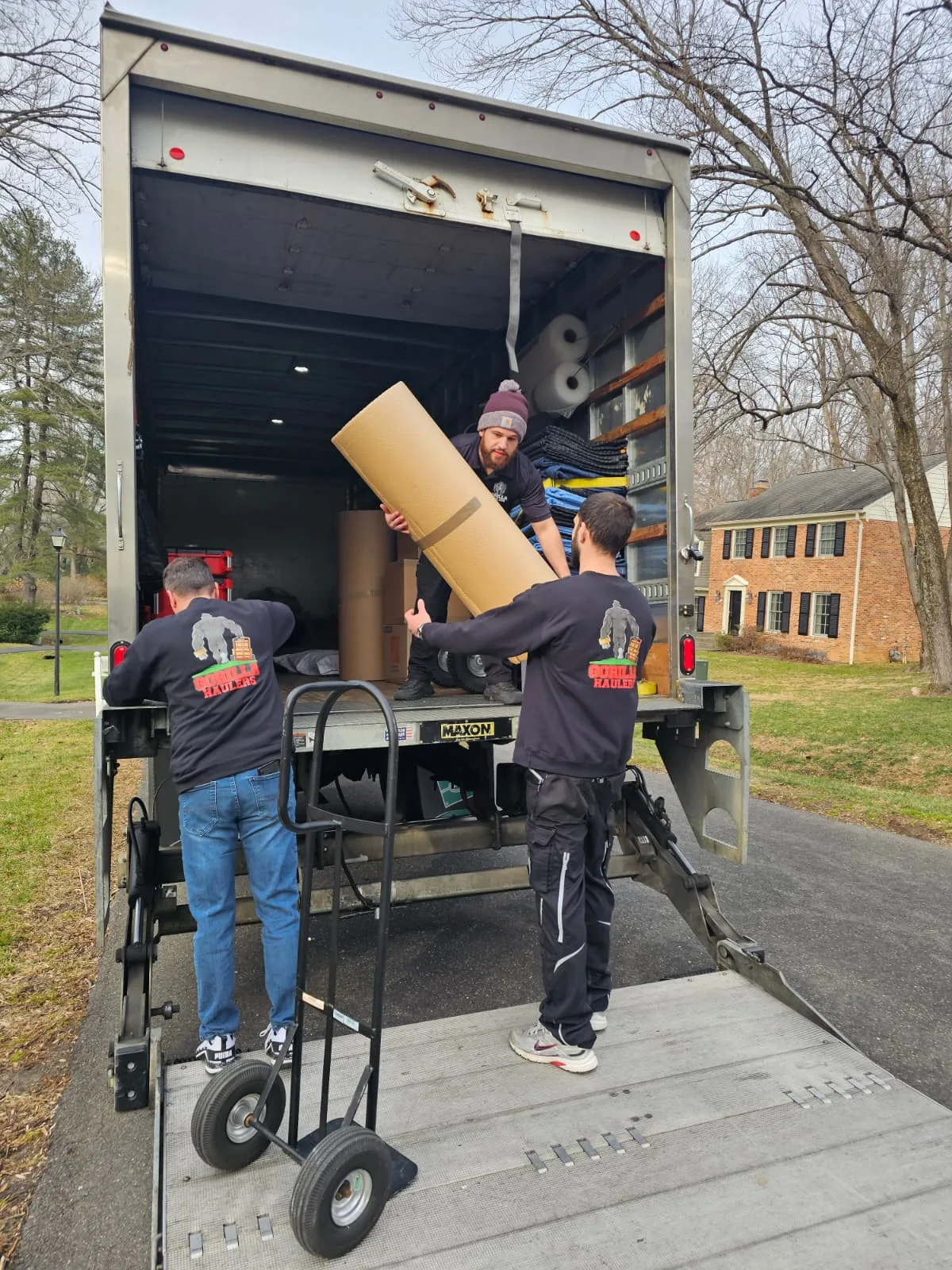 Gorilla Haulers crew beside a moving truck stocked with moving blankets, dollies and packing supplies