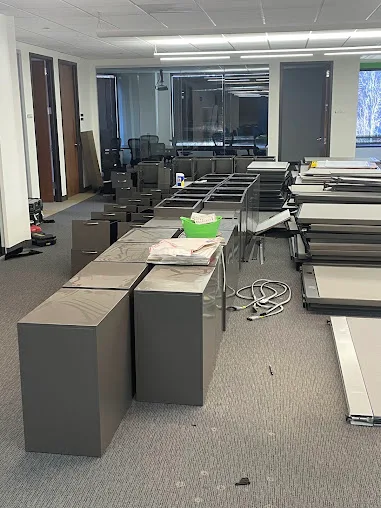 Disassembled desks, cabinets and office furniture arranged in a commercial workspace