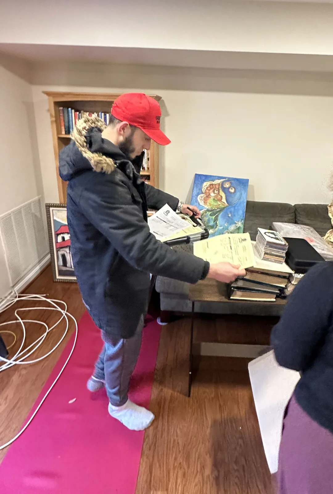 Gorilla Haulers crew leader going over and signing the moving paperwork with a customer, with a red runner laid down to protect the floor