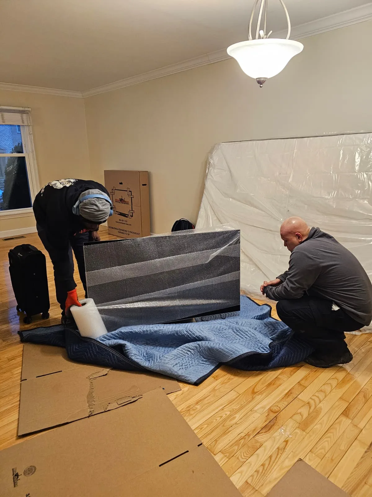 Gorilla Haulers movers cushioning and wrapping a television for moving